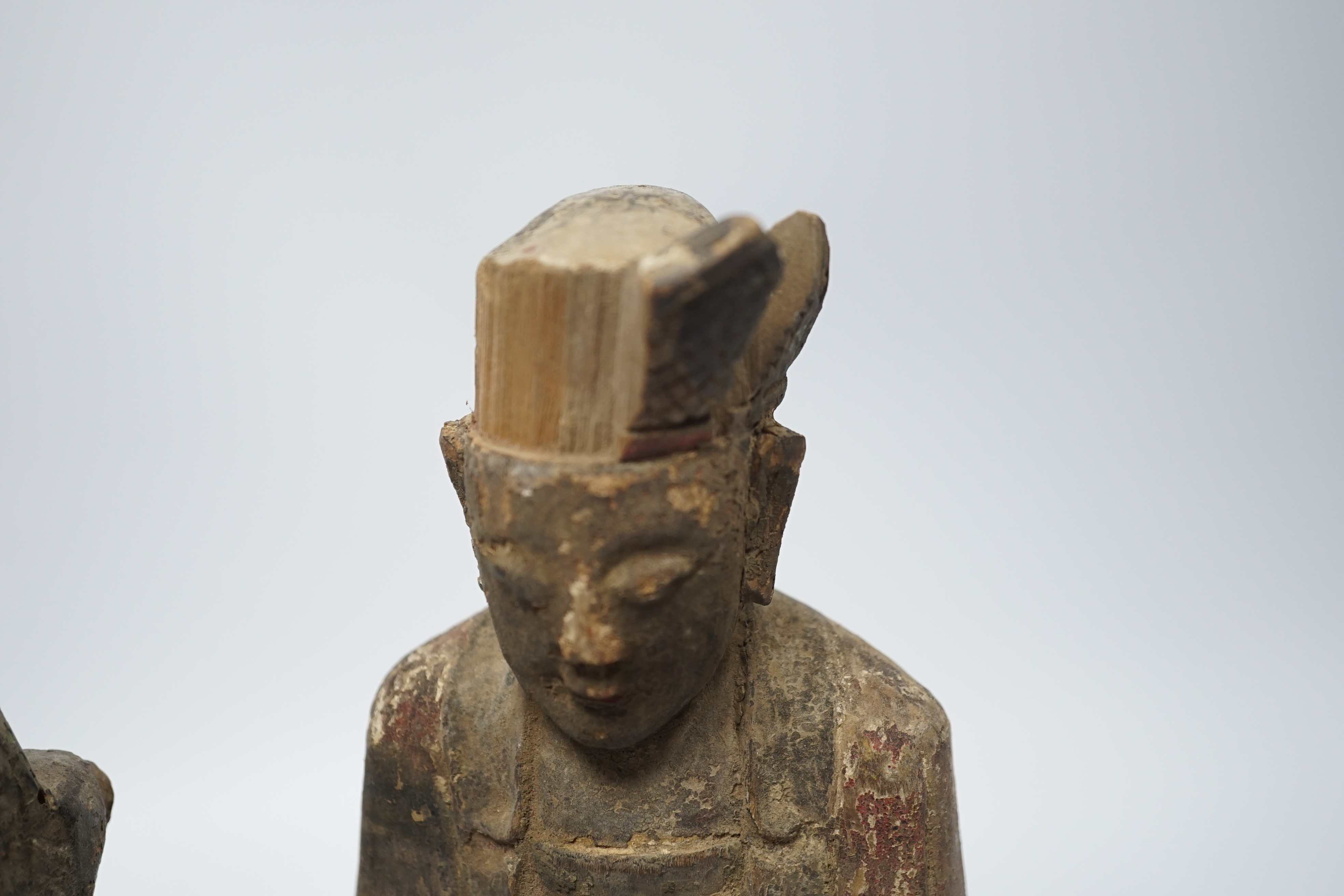 Two Chinese or Southeast Asian carved wood figures of seated immortals, and seven small wood stands, largest 24cm high